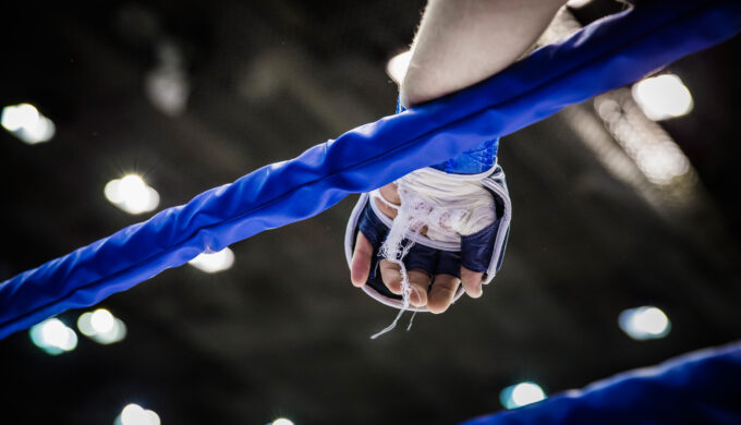 hand of fighter on ropes of ring during competition in mixed martial arts